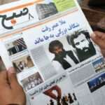 Afghan man reads a local newspaper abut the death of Omar