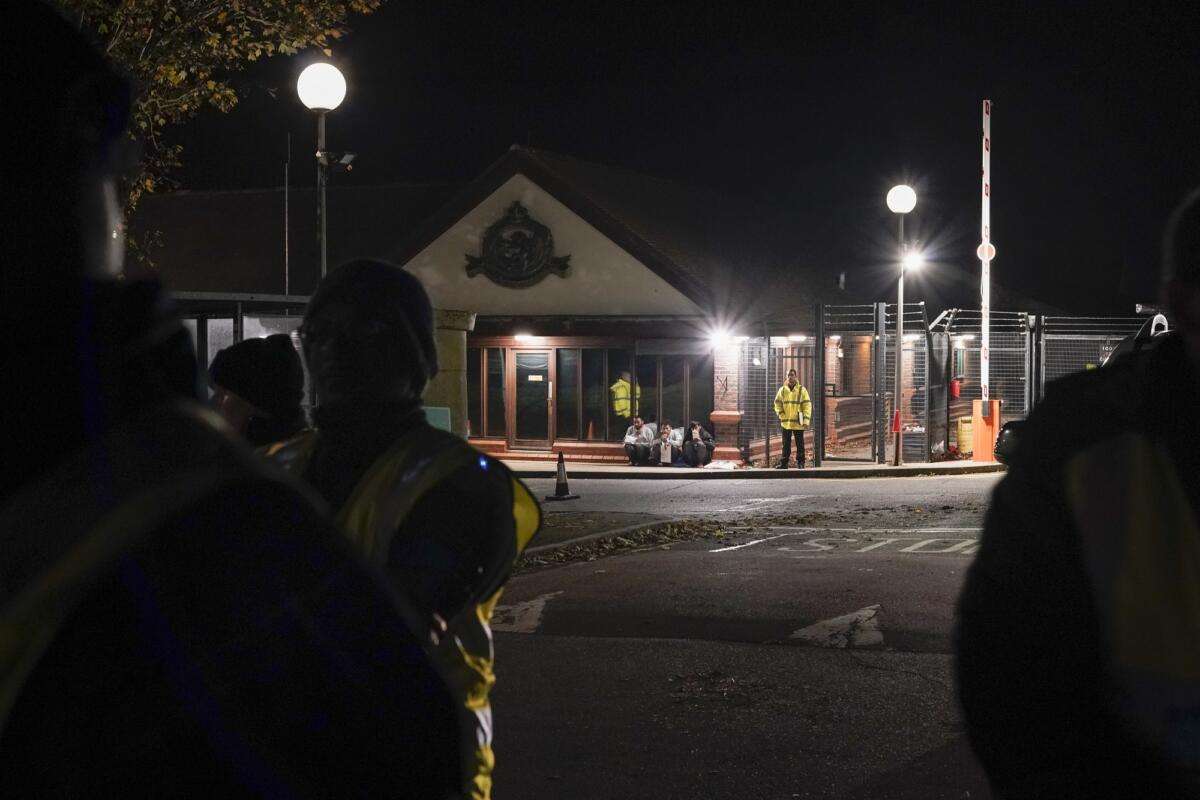 migrants sit outside the Manston immigration short term