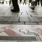 People walk near a no smoking sign on World No Tobacco Day