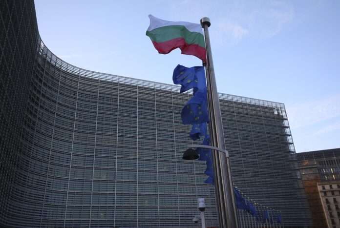The Bulgarian and European Union flags flap in the wind outside EU