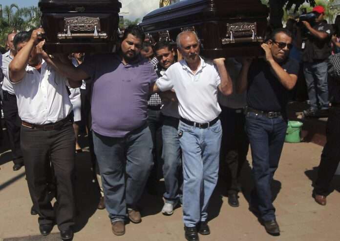 Mexico Men carry the coffins containing the remains of Mexicans