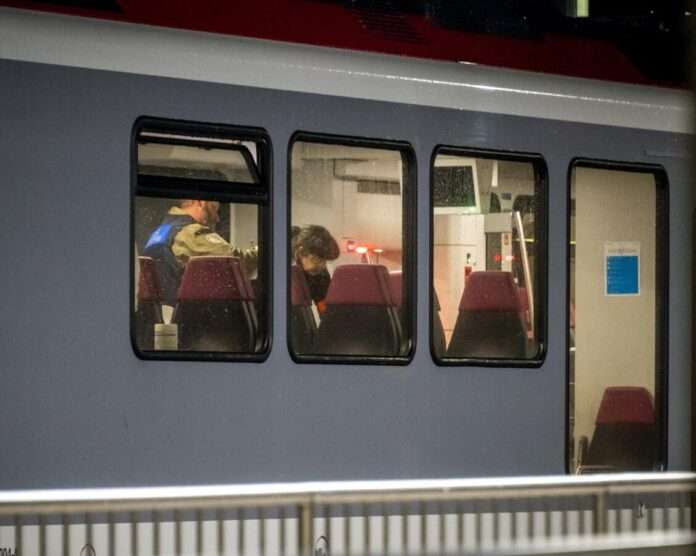 Swiss police officers inspect the inside of a train where passengers travelling from Yverdon to Sainte Croix