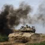 Israeli soldiers drive an tanks on the border
