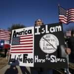 USA A protestor walks along the sidewalk outside the Curtis Culwell Center where a muslim conference against terror and hate was scheduled
