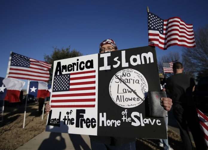 USA A protestor walks along the sidewalk outside the Curtis Culwell Center where a muslim conference against terror and hate was scheduled