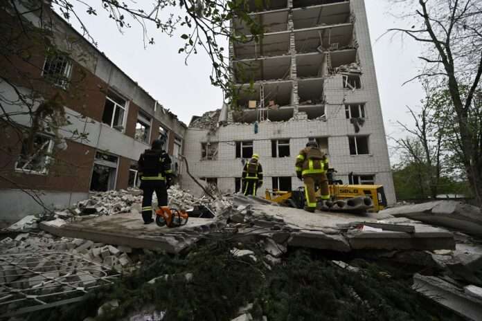 Ukrainian rescuers clear the rubbles of a destroyed building following a missile attack in Chernigiv