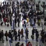 passengers queue up for a security check at Pudong International Airport in Shanghai China