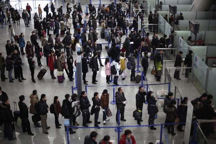 passengers queue up for a security check at Pudong International Airport in Shanghai China