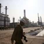 Iranian oil worker makes his way through Tehrans oil refinery