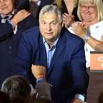 Viktor Orban gestures alongside members of the Fidesz party