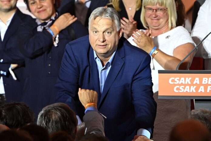 Viktor Orban gestures alongside members of the Fidesz party