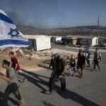 Israeli settlers carry an Israeli flag at the outpost of Eviatar near the northern West Bank town of Nablus 768x512 1