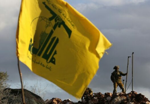 lebanon tense border israeli soldier sets up cameras at their new position in front of a hezbollah flag 768x530 1